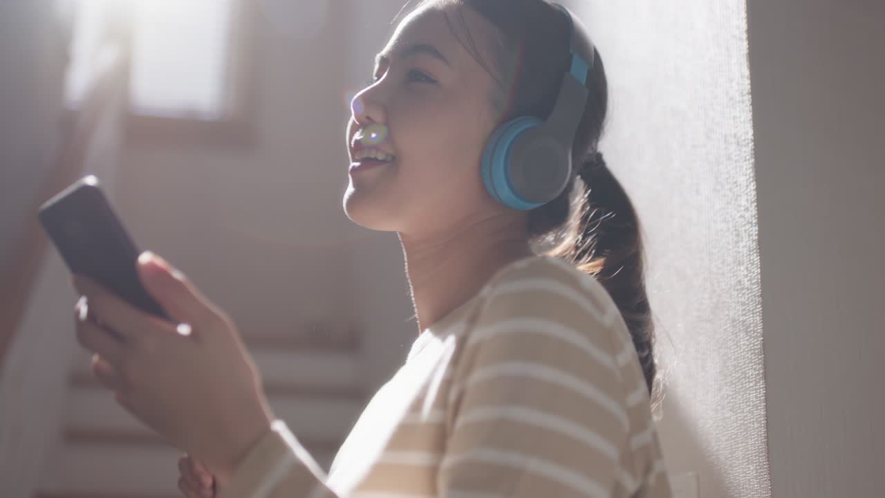 젊은 아시아 여성 음악 캐스트 드폰 댄스를 듣고 집에서 즐기세요.