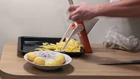 Close-up-shot-raw-potatoes-being-sliced-industrial-style-French-fry-machine