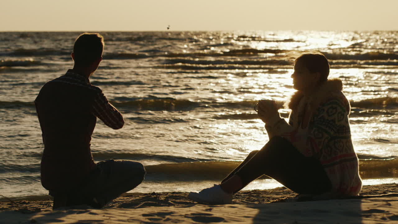 한 잔에서 차를 마시는 멋진 하루 여자에 해변이나 호수에서 휴식 로맨틱 젊은 부부는