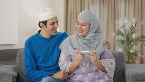 happy muslim couple checking pregnancy test