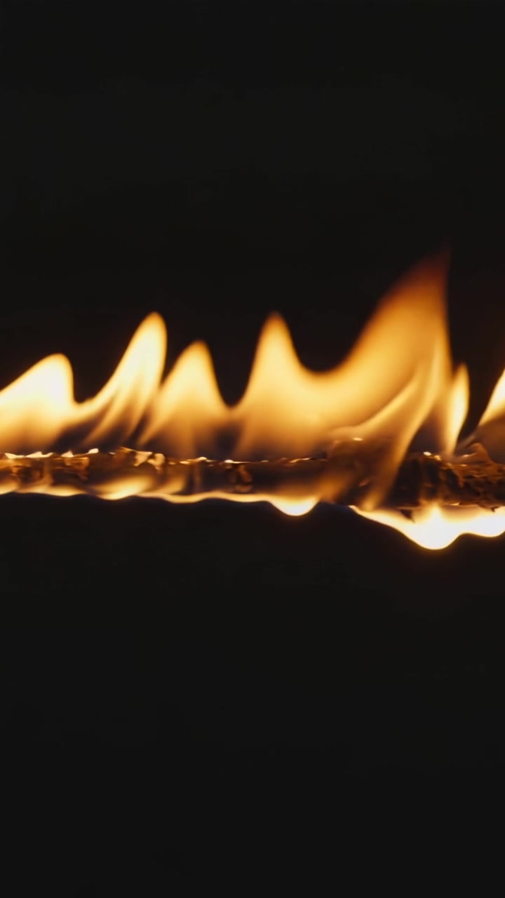 Vertical video: Rising heat causing flame band moving along fuel line in dark void, glowing beads