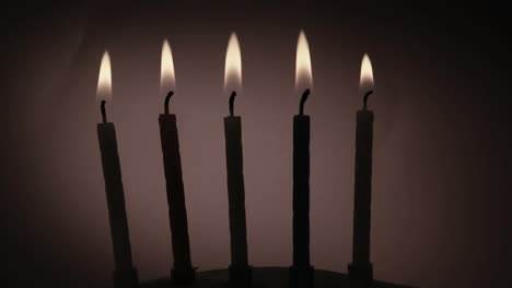 animación de formas rojas que se mueven sobre cinco velas de pastel de cumpleaños encendidas en un fondo oscuro