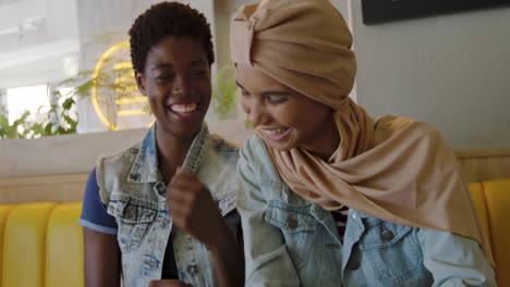 young adult female friends hanging out in a cafe