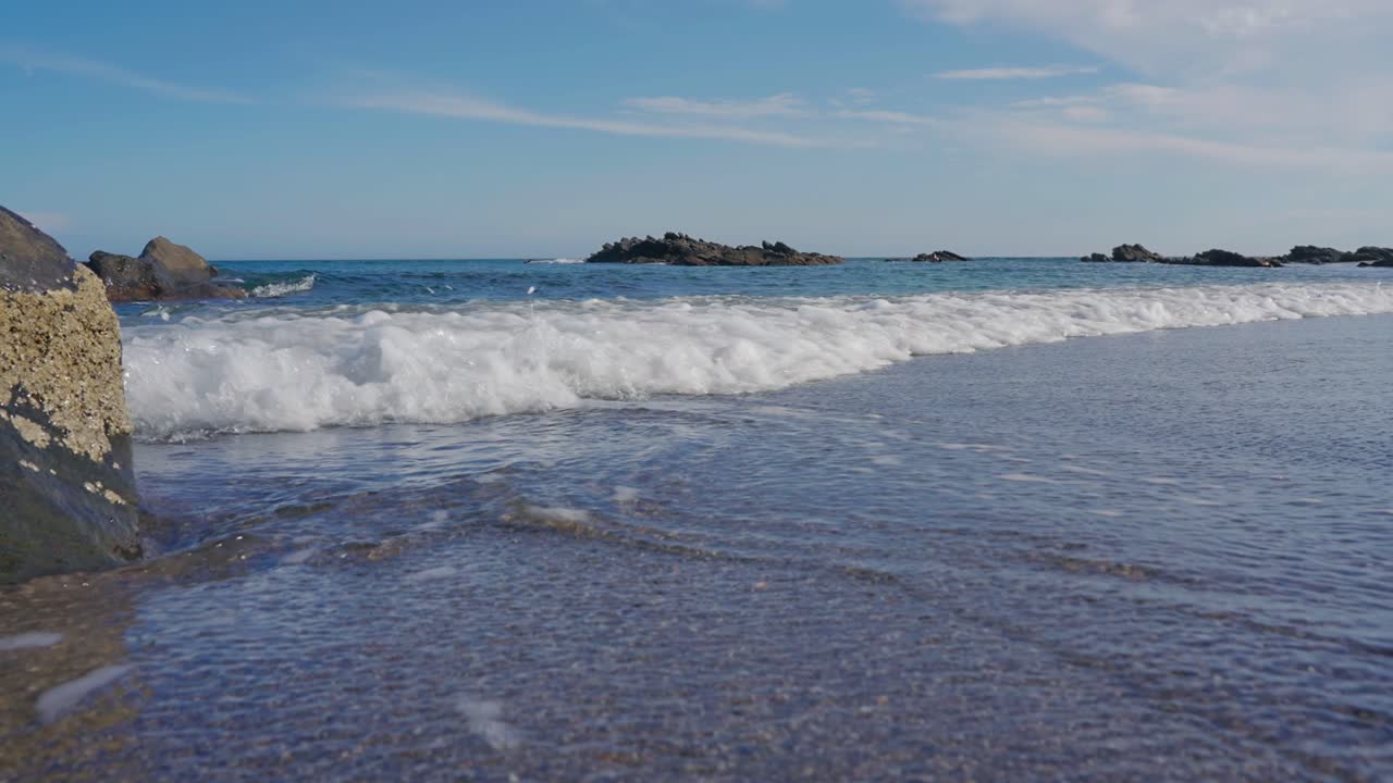 Primo piano di onde oceaniche al rallentatore sulla spiaggia
