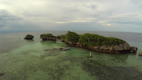 Pequeño-Grupo-De-Islas-Tropicales-De-Roca-De-Lava-Con-Un-Pequeño-Naufragio