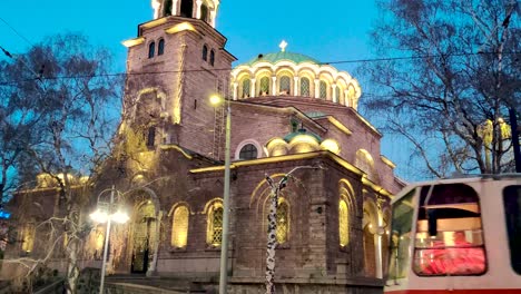 tranvía pasando frente a la iglesia de st nedelya en bulgaria durante la noche