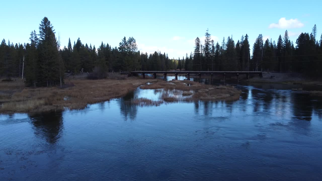 Drone footage of Island Park, Idaho, showing forest wetlands, flowing river channels, and a riverside cabin. Perfect for travel and nature projects