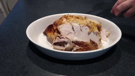 man cutting or carving a hot roast chicken