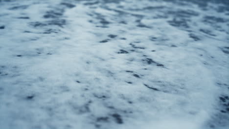 Sea-foam-breaking-beach-sand-outside.-Blue-ocean-waves-crashing-coast-background