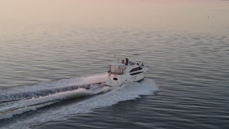 motor yacht traveling in the sea at dusk, moving fast and leaving wake