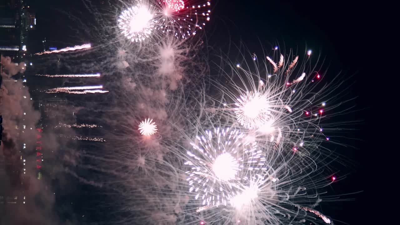 los fuegos artificiales de la víspera de año nuevo exhiben un bucle de celebración sin costuras de fondo de fuegos artificiales reales con un gran espectáculo de fuegos artificiales brillantes multicolores abstractos con luces bokeh en el cielo nocturno