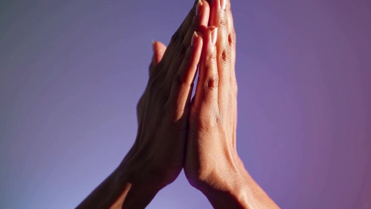 Gros plan sur des mains jointes en prière ou en méditation