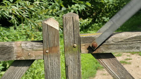 Man-closing-latch-on-farm-gate