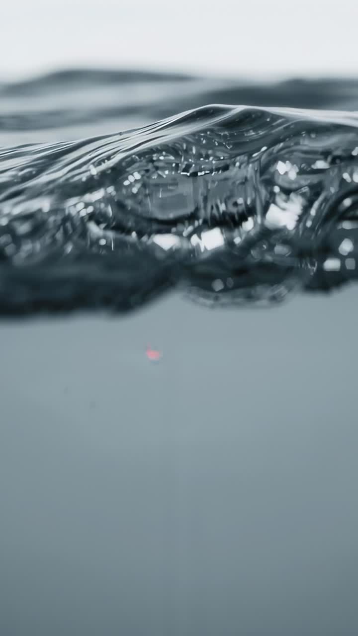 Vertical video: Starting macro camera filming sea surface to study ripples, droplets, horizon