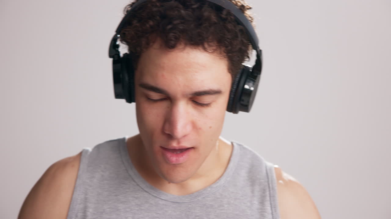 Giovane uomo con cuffie che ascolta musica su smartphone
