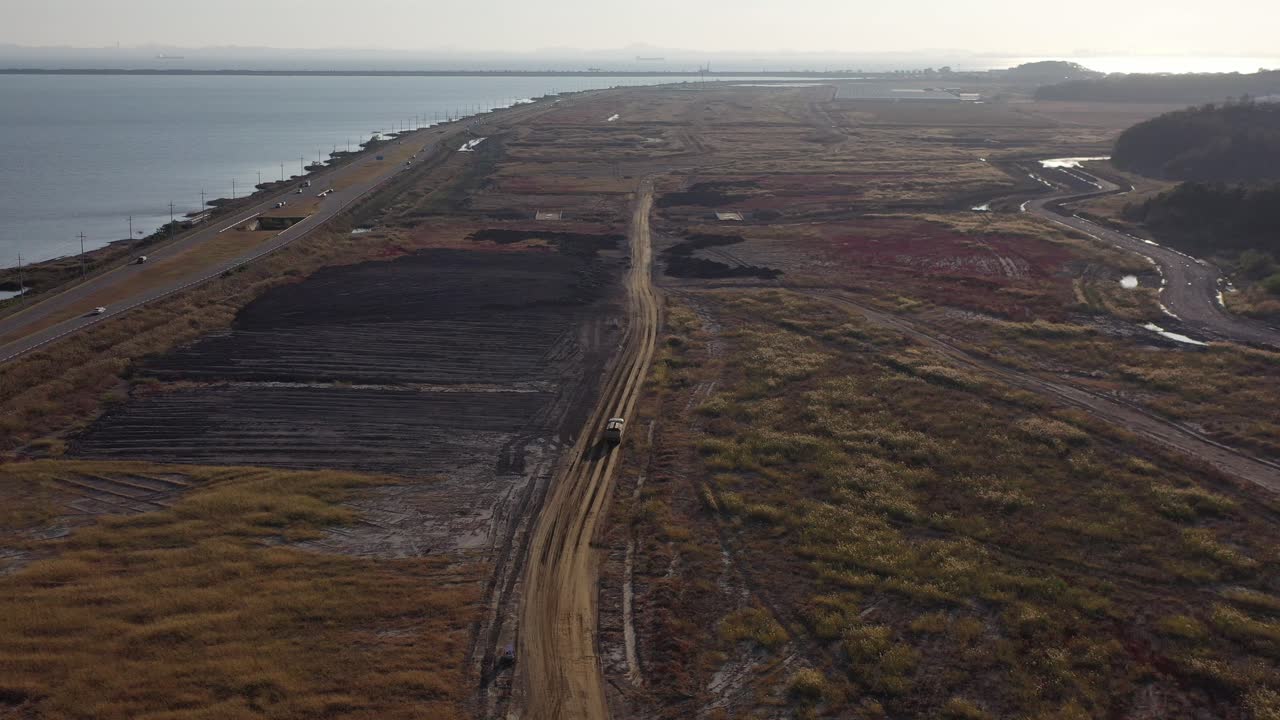 un vehículo blanco que corre entre plantas nativas en tierras recuperadas