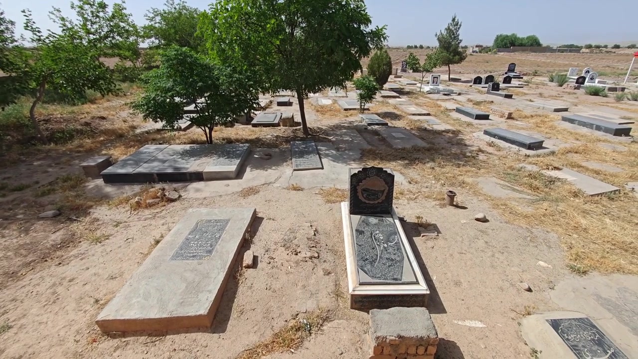 Vista de un cementerio tranquilo con tumbas tradicionales y árboles