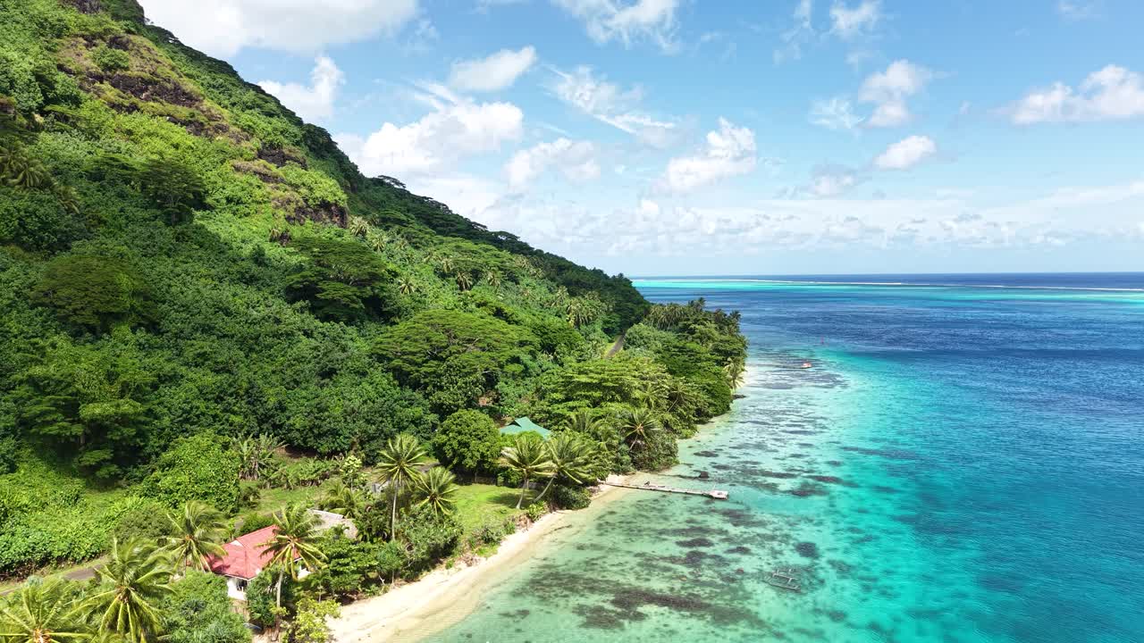 Huahine Island, French Polynesia. Drone Shot of Beach, Beachfront Homes, Road and Green Rainforest om Hills