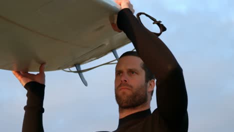 low angle view of mid-adult caucasian male surfer carrying surfboard on his head at the beach 4k