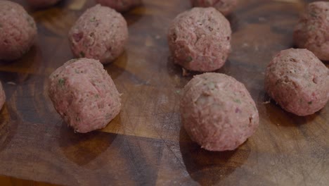 fresh meat balls on wooden cut board