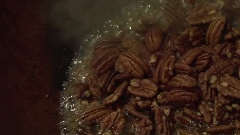 close up slow motion shot of pecan nuts being roasted and caramelised