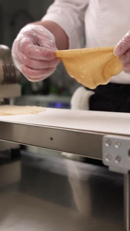 chef preparing dough on conveyor belt