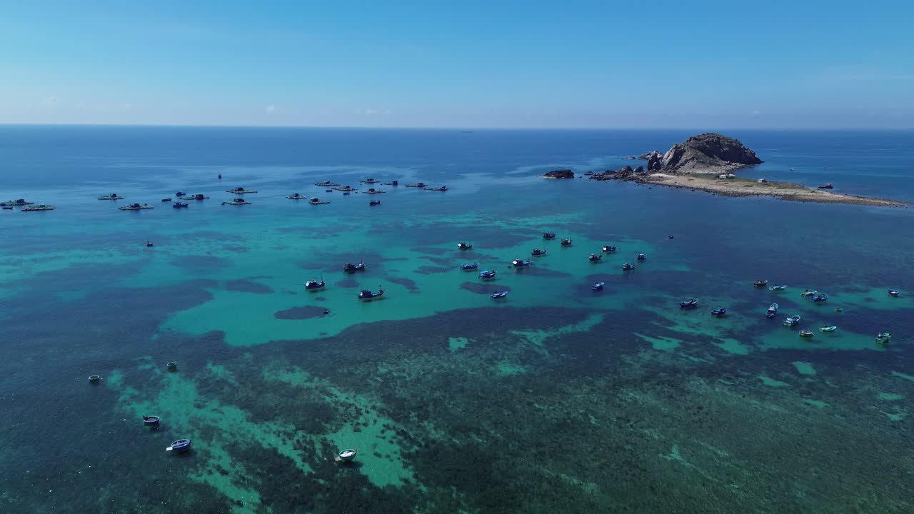 Aerial movement lifting the view from the traditional fishing boats towards the broader village and coastline of Ninh Hải.