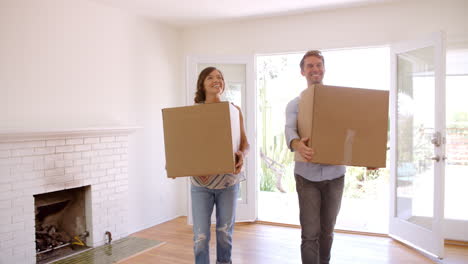 couple carrying boxes into new home on moving day