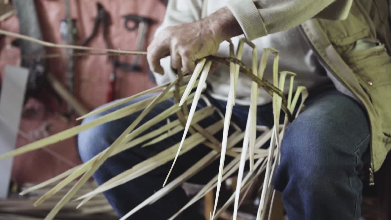 Turkish master weaves baskets from wooden sticks. 4K close-up. Craft concept.