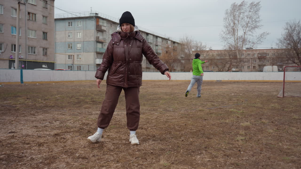 jóvenes jugadores disfrutan de un partido informal; varias generaciones participan en un partido de fútbol relajado en un campo de la ciudad; partido amistoso entre hombres y mujeres de diferentes edades en un campo de deportes urbano