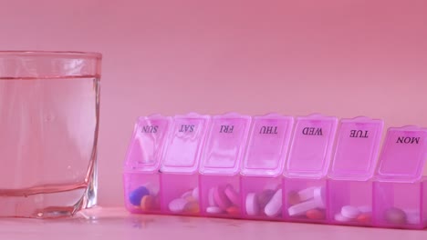 pink pill organizer with water