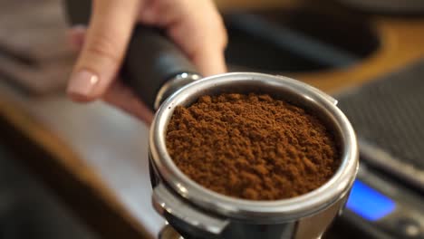 slowmo - fresh ground coffee beans in portafilter - close up