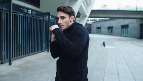 Young-man-boxing-in-urban-street.-Portrait-of-kickboxer-training-punch