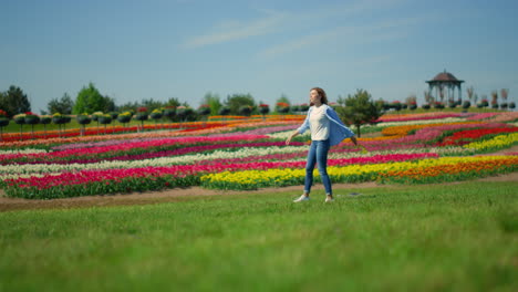 Unknown-woman-in-casual-clothes-walking-in-beautiful-spring-garden-in-daytime.