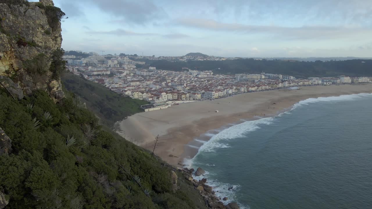imágenes de drones de la ciudad de nazare en la costa de portugal filmadas durante la hora dorada del atardecer 4k