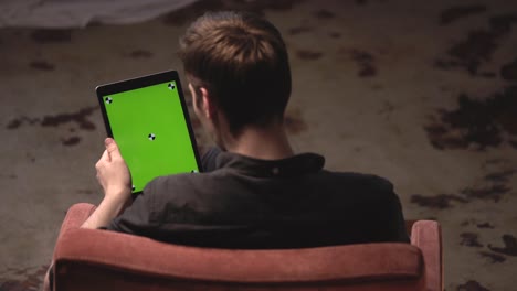 man using a tablet with green screen