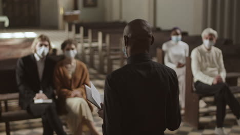 priest wearing mask preaching sermon