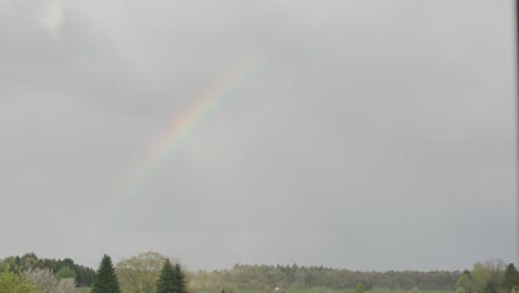 arco iris que aparece en el cielo sobre el barrio después de la tormenta en la tarde, alemania, europa