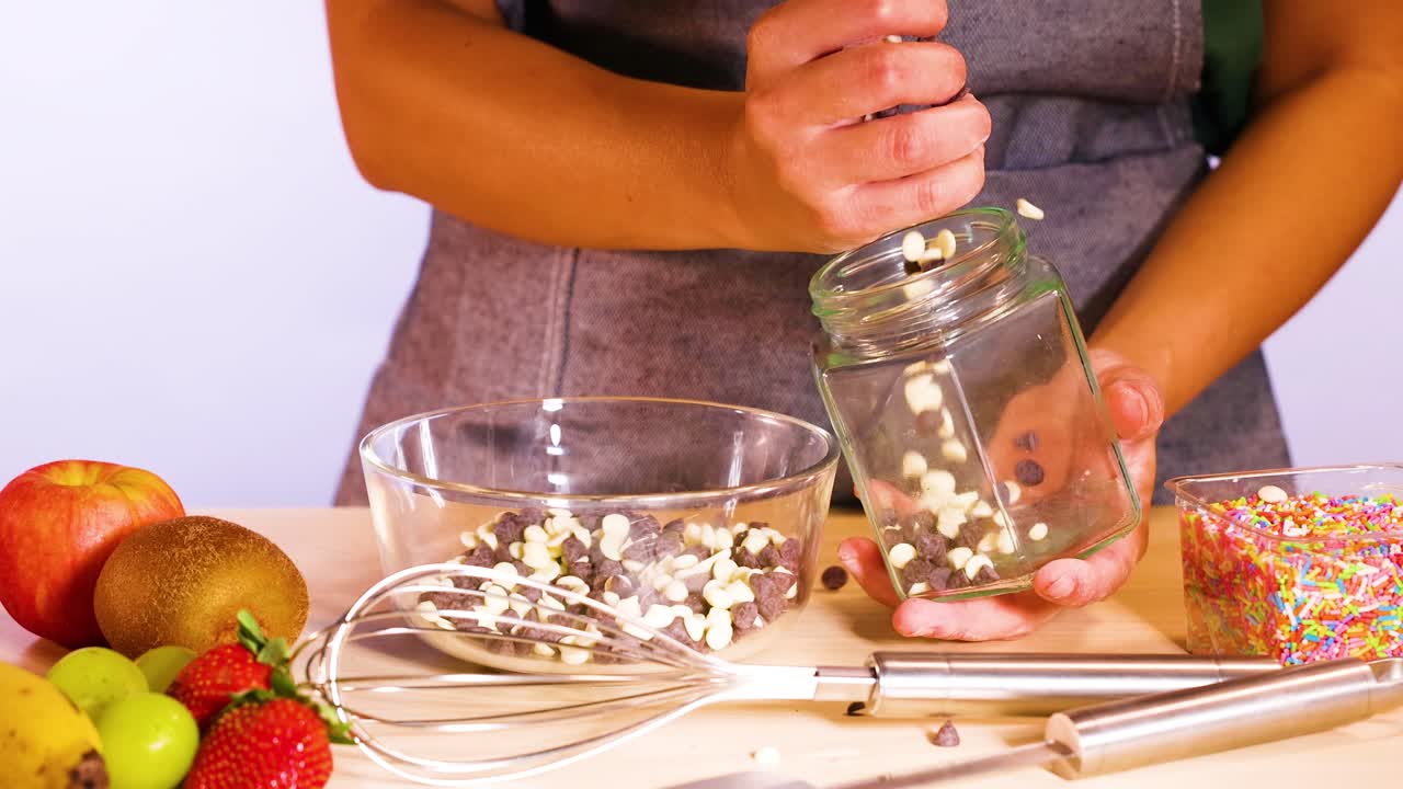 persona llena el frasco con chips de chocolate blanco