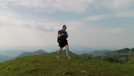 slow-motion-of-solo-traveller-female-backpacker-walking-alone-on-mountains-crest-path