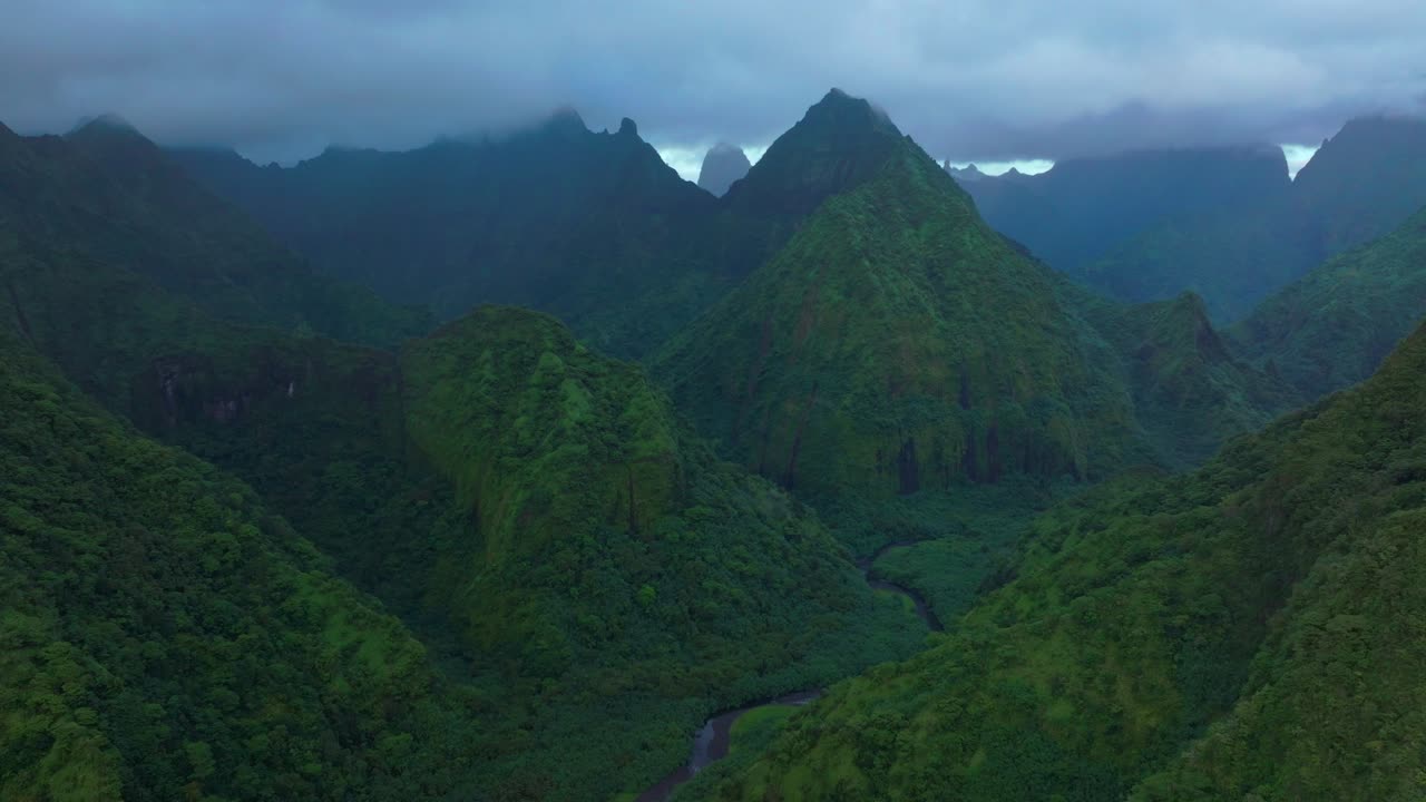 Bulutlu sabah yüksek sivri dağ zirveleri Tautira Nehri Vadisi Tahiti adası Fransız Polinezyası havadan drone Teahupoo Vadisi Koyu Mont Rauiri Aorai Taiarapu Taravao geriye doğru yukarı kaydırma paralaks hareketi