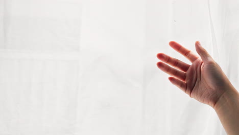 Close-up-asian-woman-dragging-her-hand-on-clean-white-curtain-gently-at-home---relaxing-soft-comfortable-concept