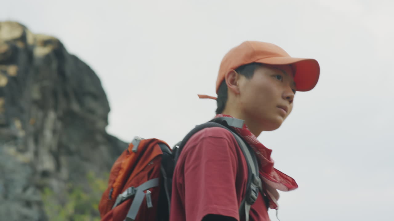 Asian Female Tourist Trekking in Mountains