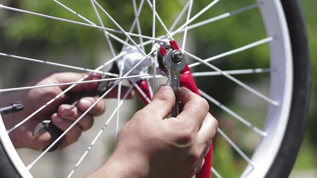 Person fixing a bicycle wheel with wrenches. Repairing a bicycle axis. Bike restoration