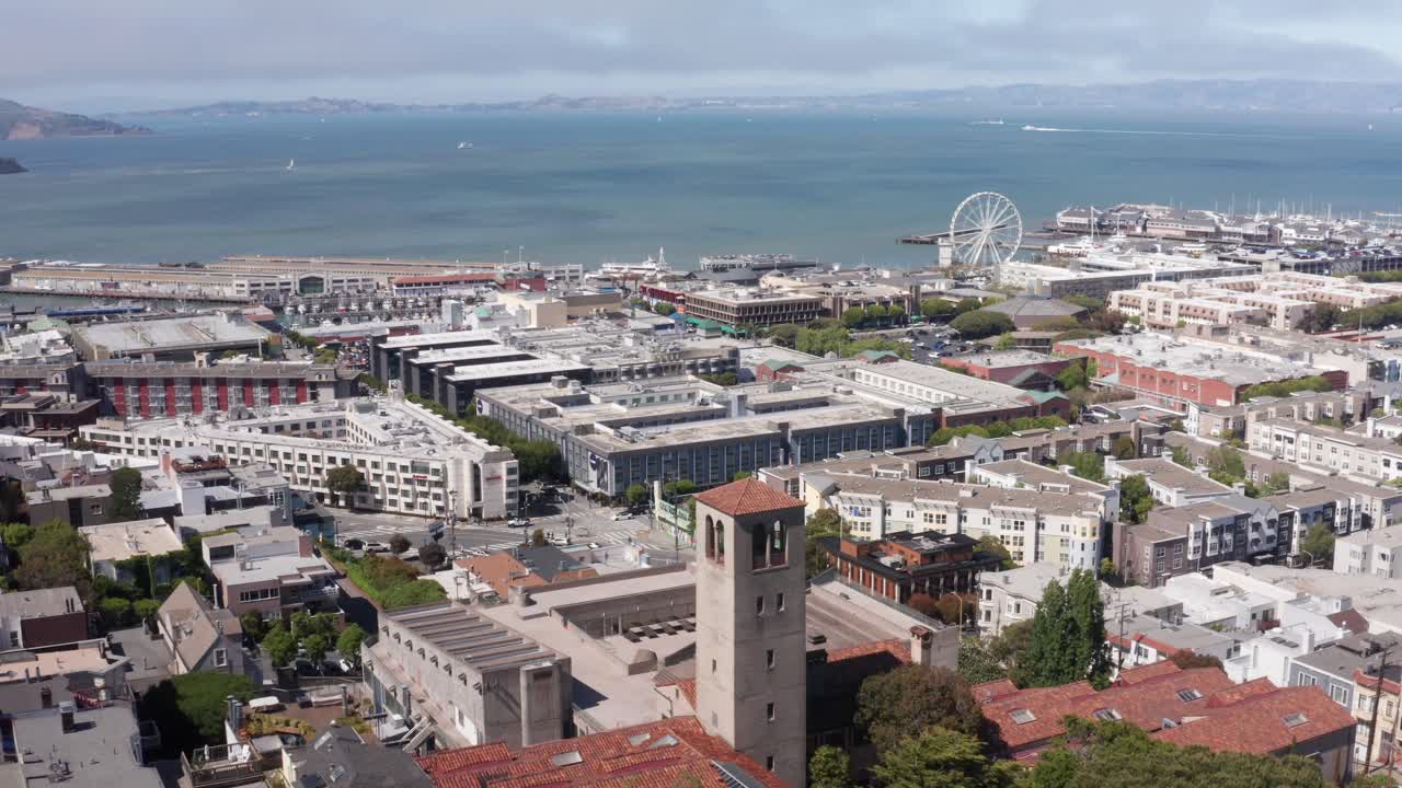 Aerial wide descending shot of Fisherman's Wharf and Alcatraz Island from Lombard Street on Russian Hill in San Francisco, California