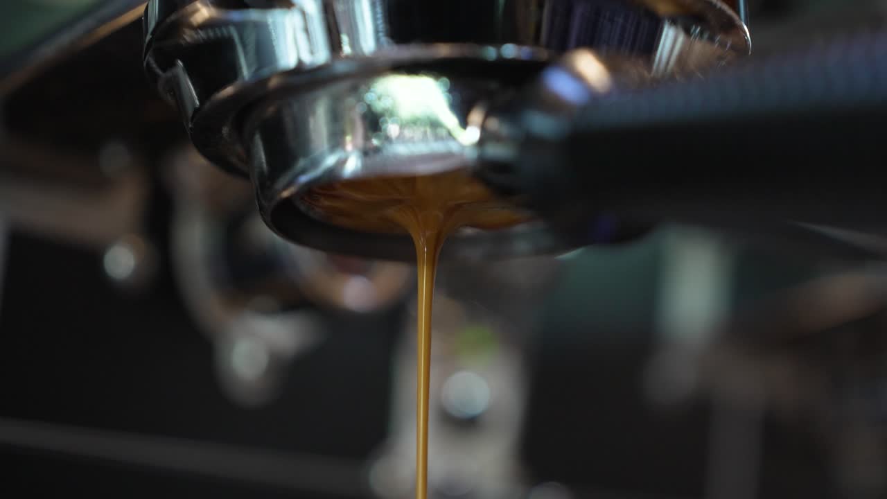 A rich espresso stream flows smoothly from the portafilter spout