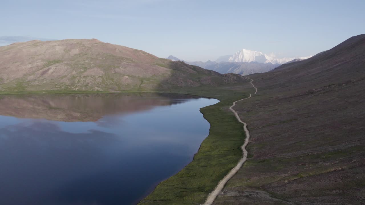 Deosai Milli Parkı'nda yer alan Şeosar Gölü ve kıvrımlı yol, uzakta Nanga Parbat zirvesiyle birlikte