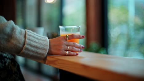 woman drinking orange juice in a cafe