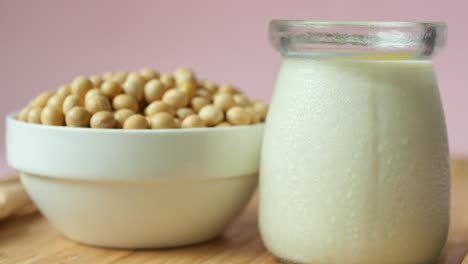 Close-up-of-soya-milk-in-a-small-glass-jar-on-pink