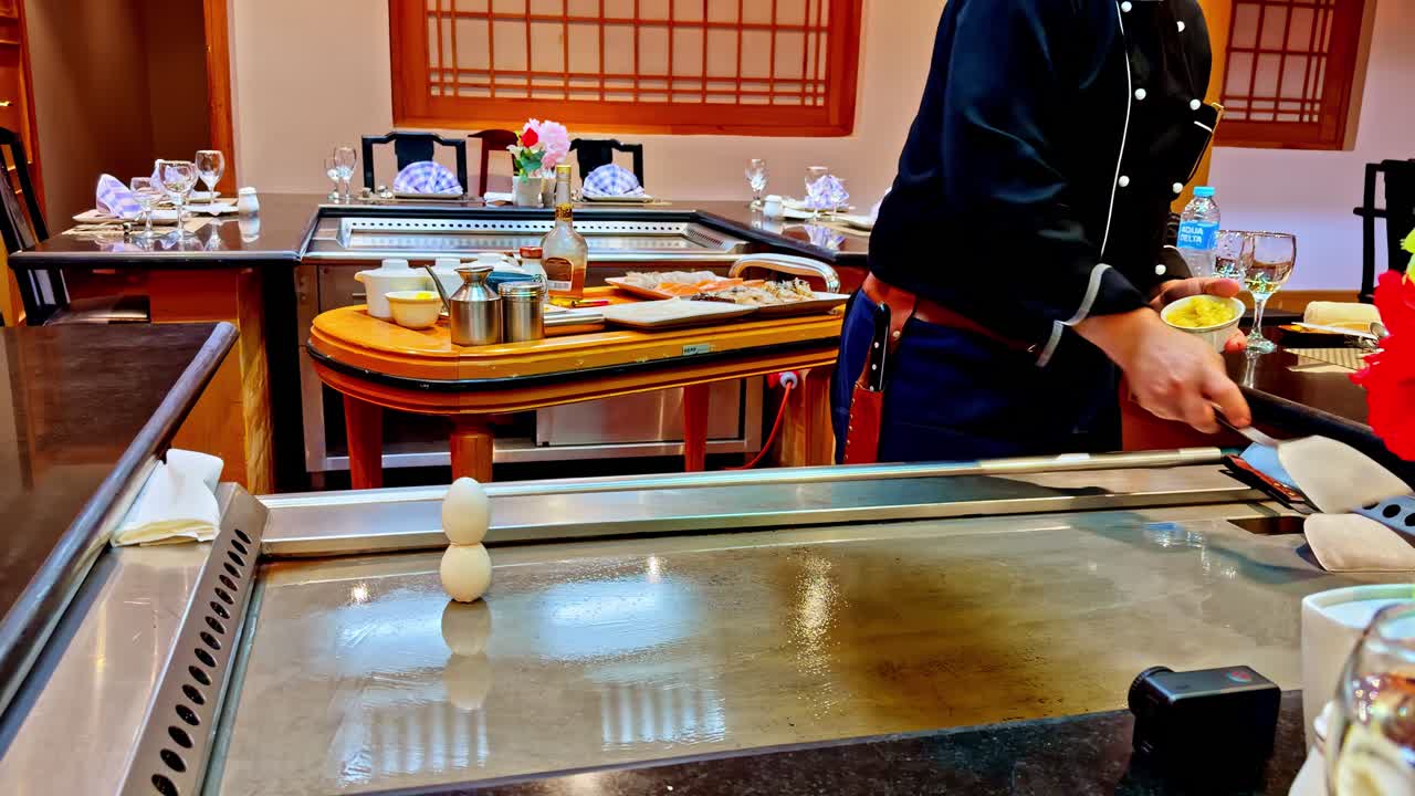 Hotel restaurant chef pouring oil on the griddle. Slow motion